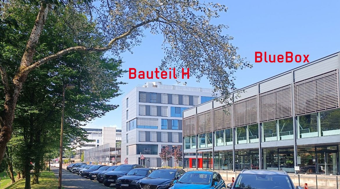 Foto von zwei Gebäuden. Das hintere ist mit Bauteil H beschriftet, das vordere mit BlueBox