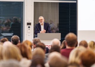 Hochschulpräsident Prof. Dr. Andreas Wytzisk-Arens hält einen Vortrag vor großen Publikum