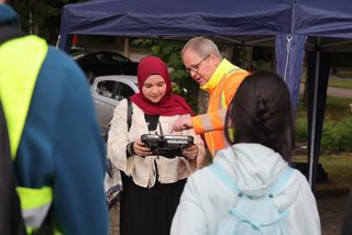 Schükerin betrachtet Vermessungsinstrument.