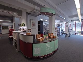 Blick auf die Saatgutbibliothek im Eingangsbereich der Fachbibliothek Technik mit den Saatgutkästen, passenden Büchern und Deko