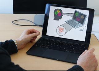 Das Bild zeigt eine Präsentationsfolie auf einem Laptop, die erläutert, dass Blickbewegungen Rückschlüsse auf kognitive Prozesse zulassen.